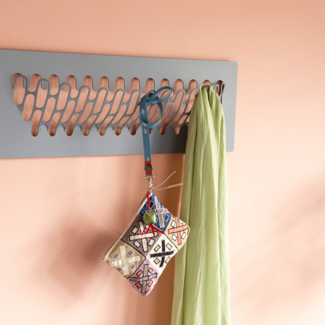 Graue Stahlgarderobe an lachsfarbener Wand