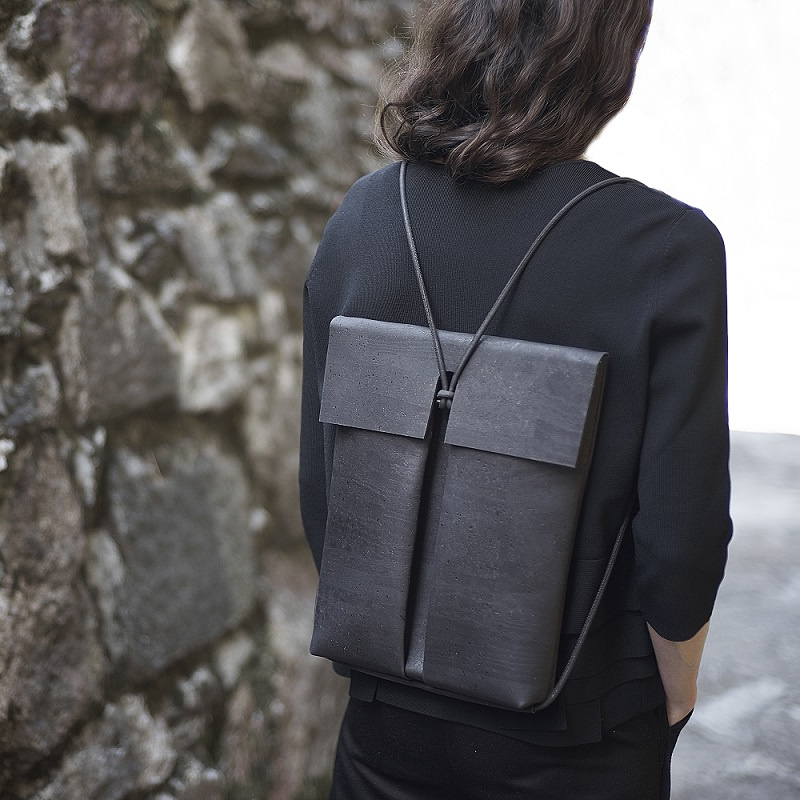 Schwarzer, klar geschnittener und eleganter Rucksack aus Korkleder. Getragen von einem Model.