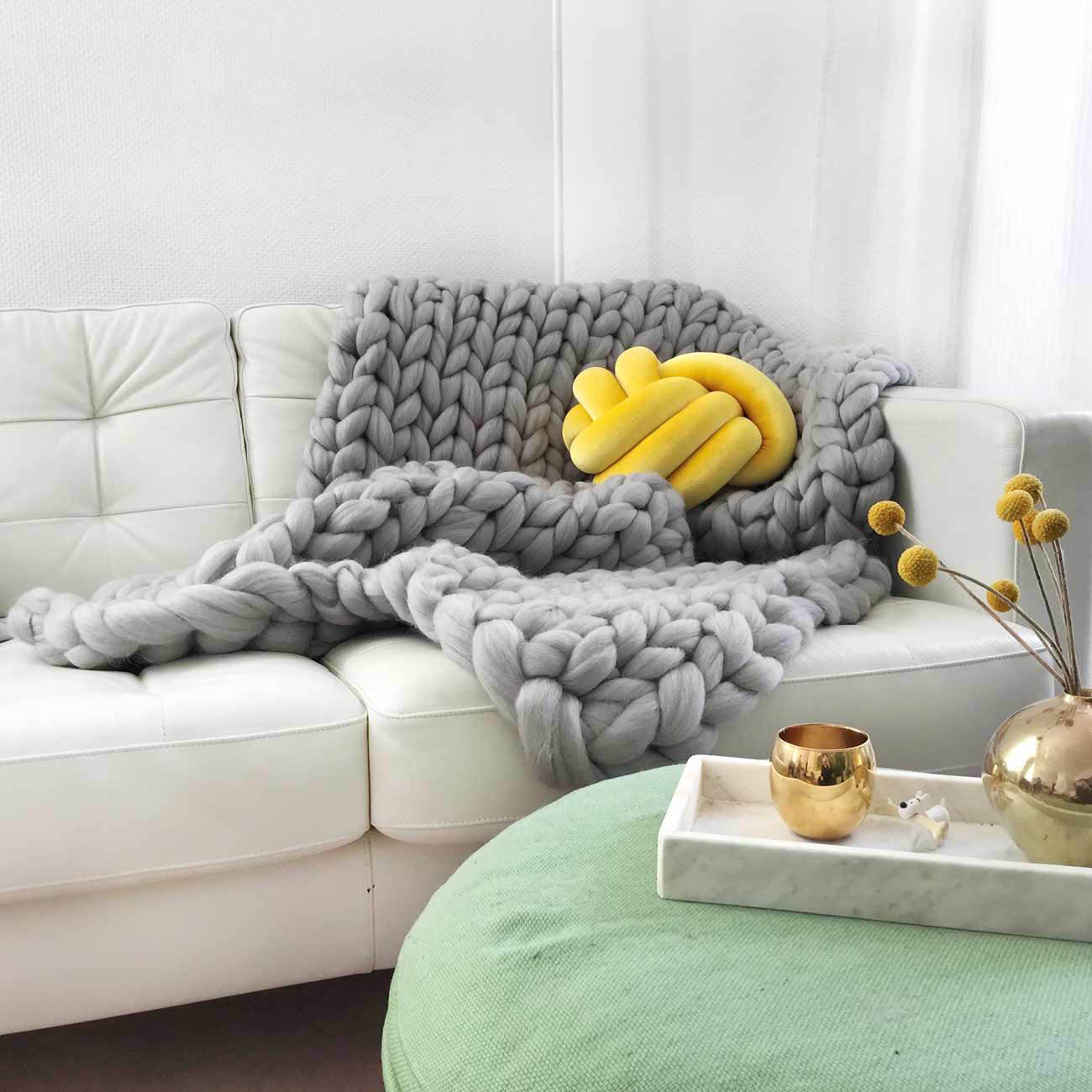 Grobmaschig gestrickte graue Decke von adorist in Kombination mit rundem gelben adorist-Kissen